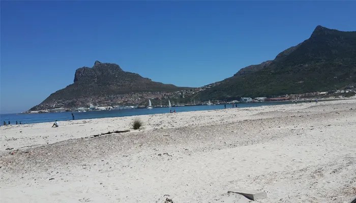 Beach with mountains in the background under a clear blue sky