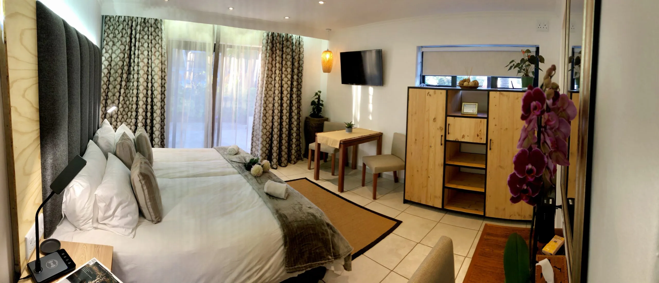 Modern hotel room with two beds wooden cabinet and large windows