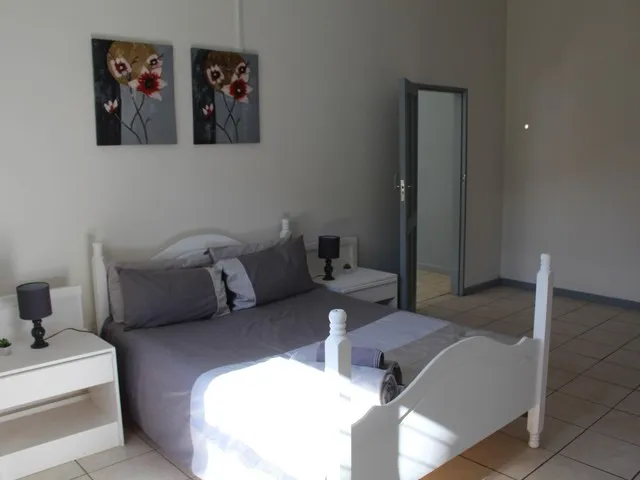 Bedroom with double bed bedside tables lamps and floral wall art