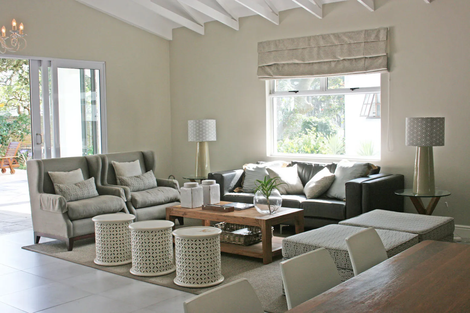Bright living room with sofas coffee table and large windows overlooking garden