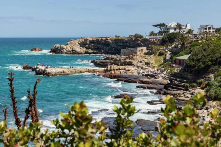 Rocky coastline with buildings on a cliff overlooking the ocean