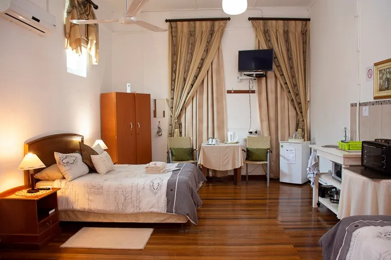 Bedroom with a double bed wooden floor and a small dining area