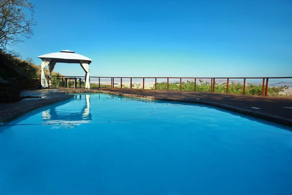 Swimming pool with gazebo and ocean view on a sunny day