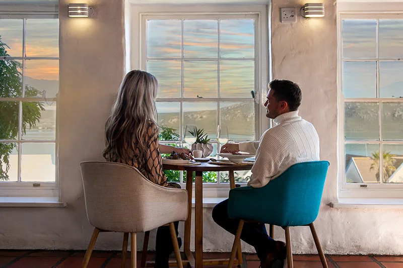 Couple sitting at a table by a window with a scenic view