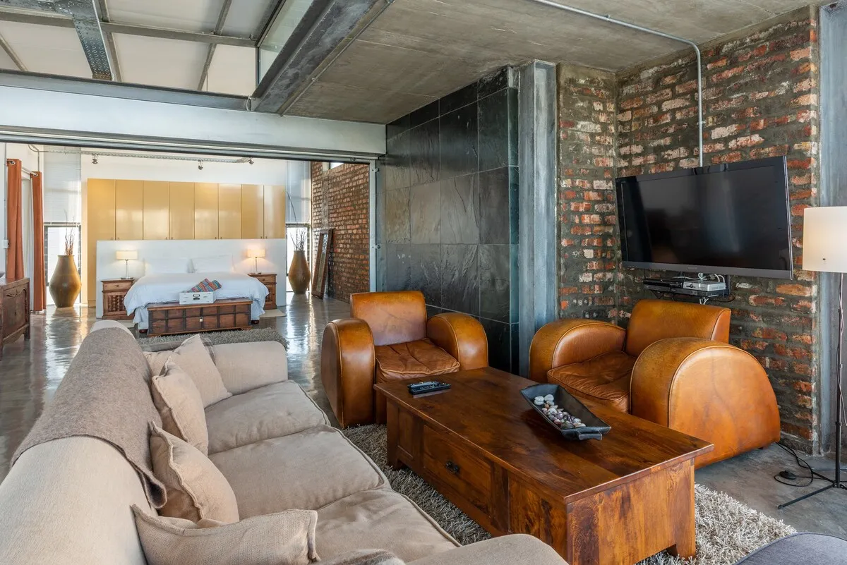 Modern living room with leather chairs sofa coffee table and large TV