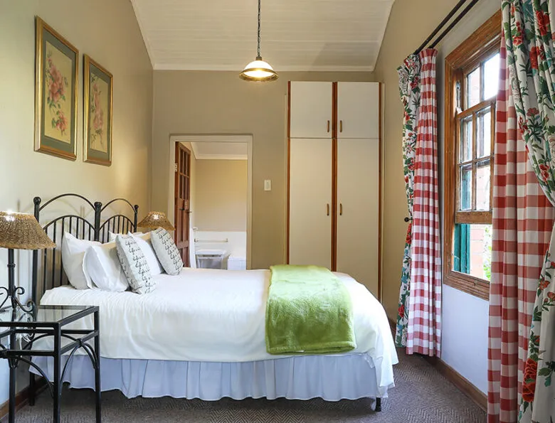 Cozy bedroom with a large bed floral curtains and two framed pictures
