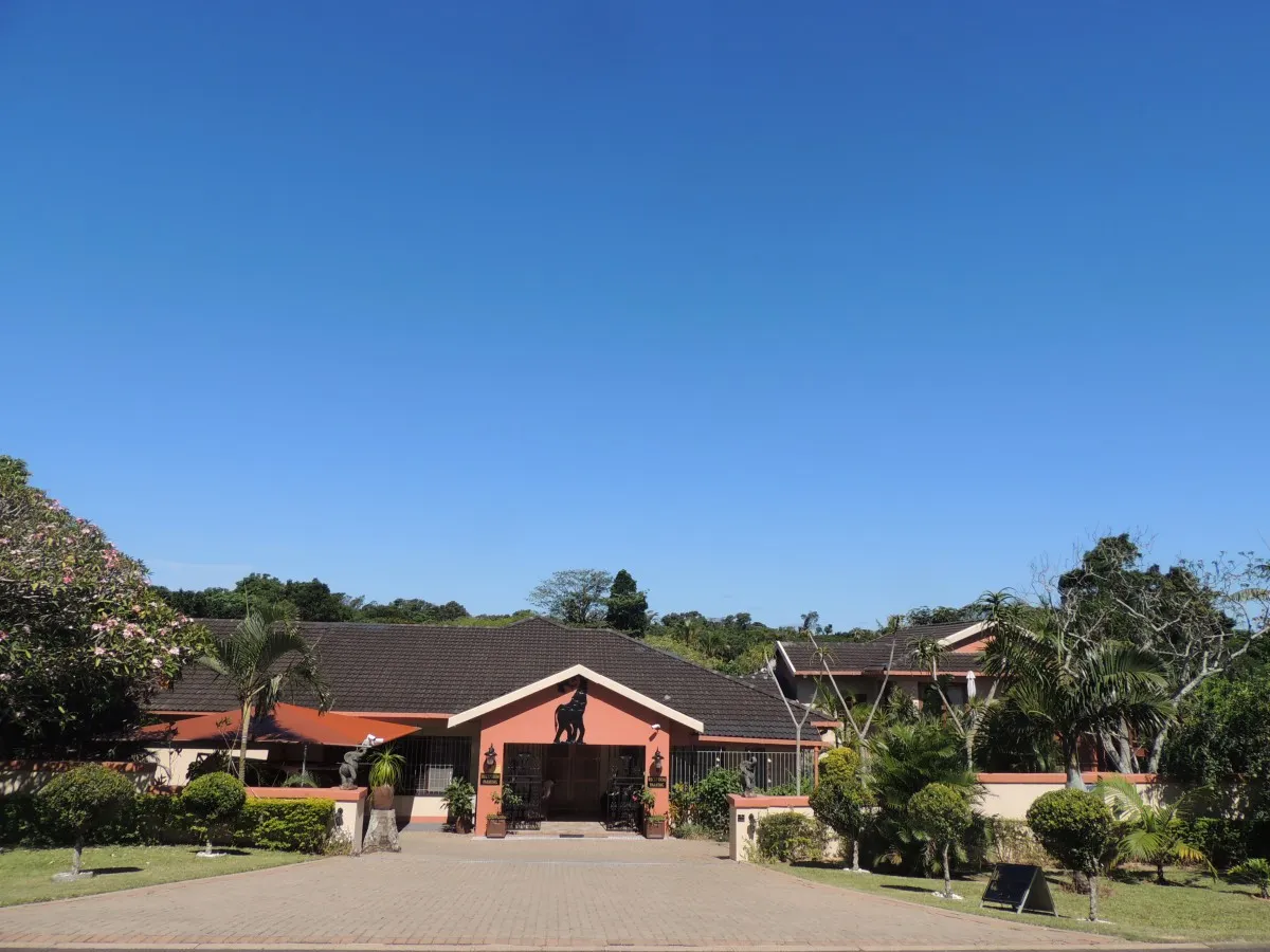 Singlestory house with red roof garden and clear blue sky