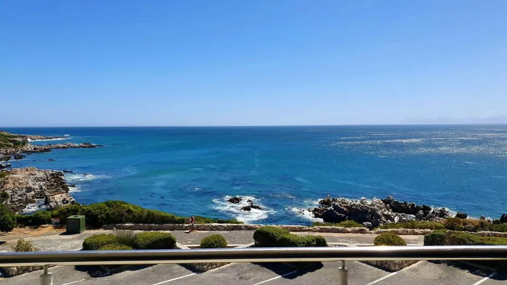Ocean view with rocky coastline and clear blue sky from a balcony