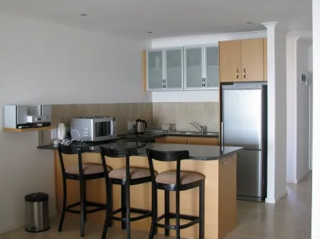 Modern kitchen with breakfast bar stools and stainless steel appliances