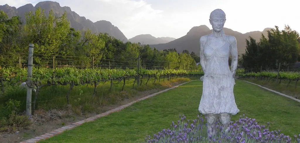 Statue in a vineyard with mountains in the background