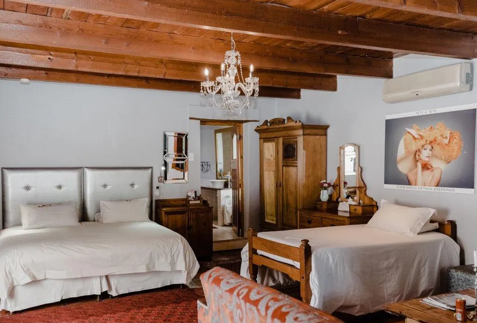 Two beds in a cozy bedroom with wooden ceiling and vintage furniture