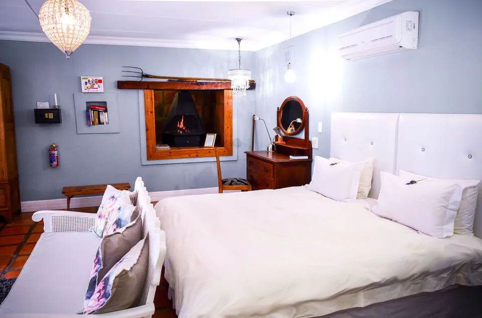 Cozy bedroom with white bed fireplace and vintage decor