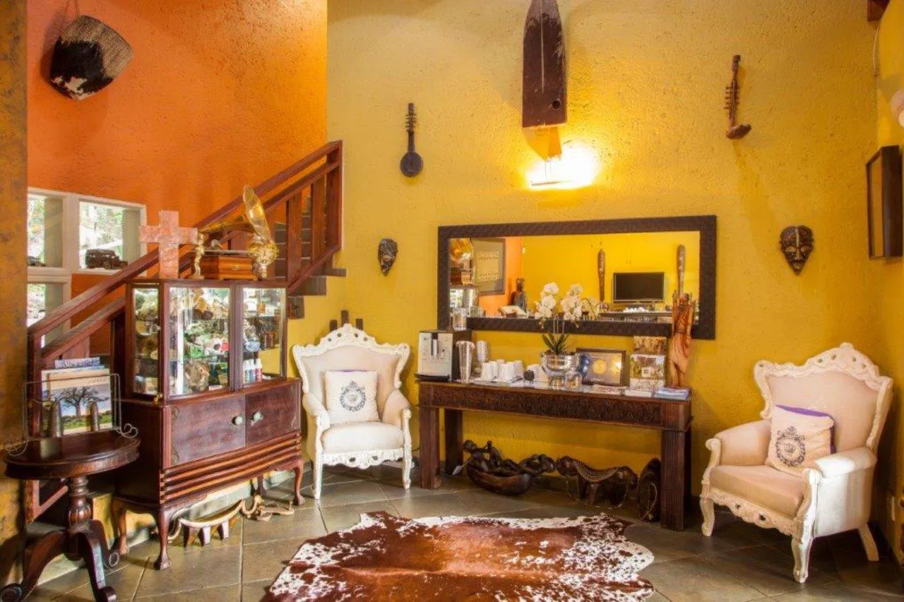 Cozy living room with eclectic decor including chairs a table and wall art