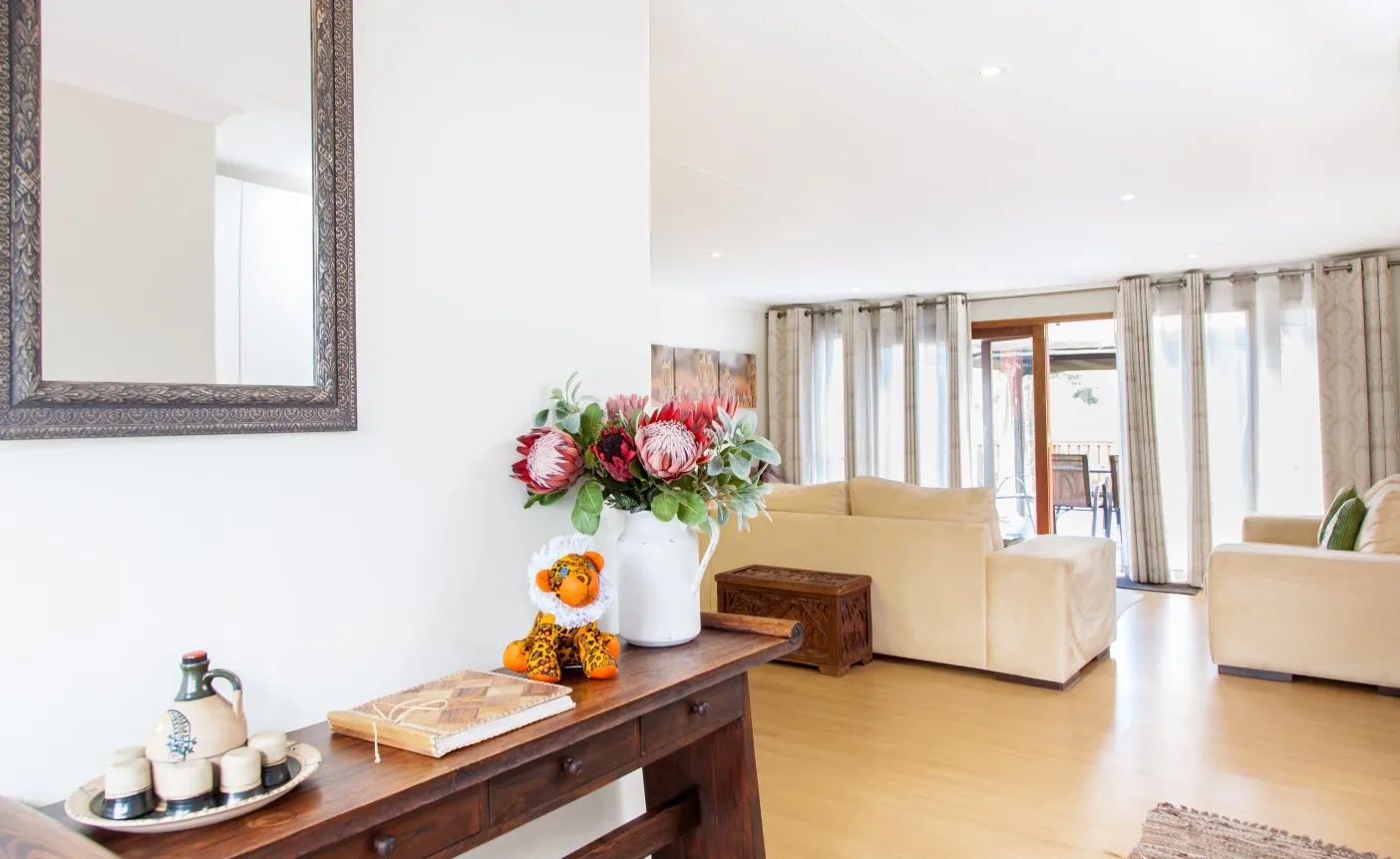 Wooden table with decor items in a bright modern living room with sofas