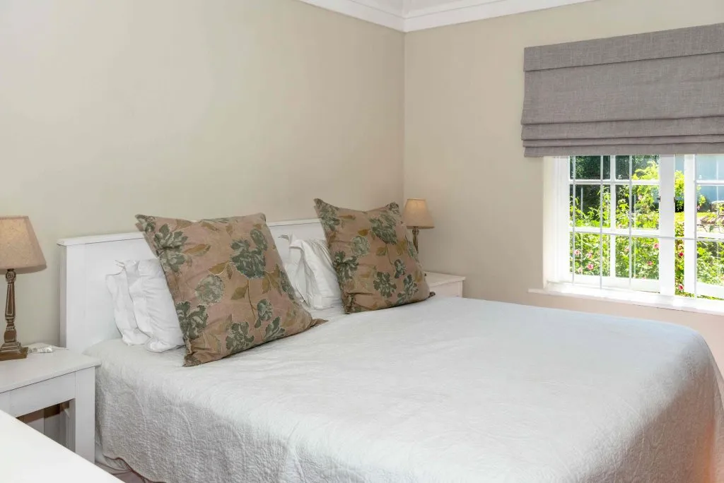 Neat bedroom with a double bed two pillows and a window with a view