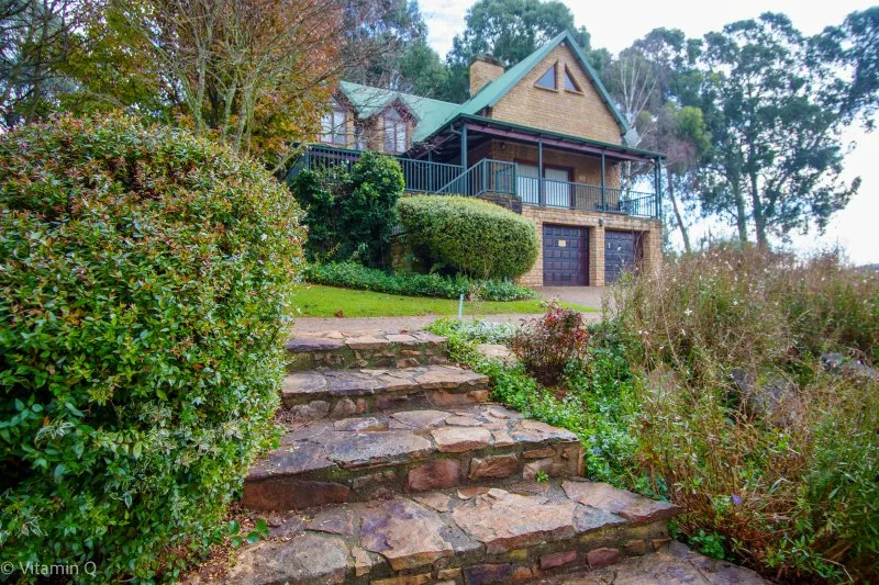 House with stone steps leading up to a garden and garage