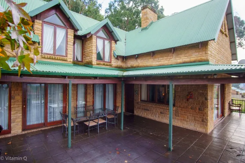 Twostory house with green roof large windows and outdoor seating area