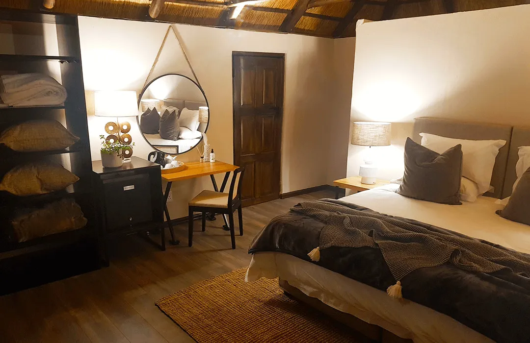 Cozy bedroom with large bed vanity mirror and warm lighting