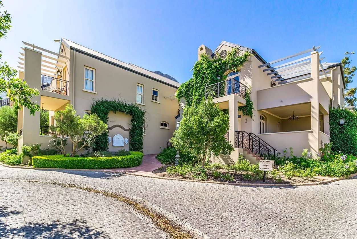 Modern house with greenery cobblestone driveway and blue sky background