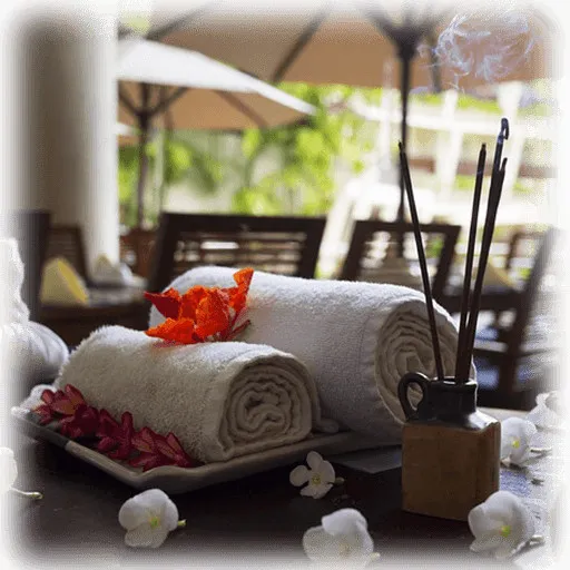 Towels with flowers on a tray incense sticks and white flowers on a table