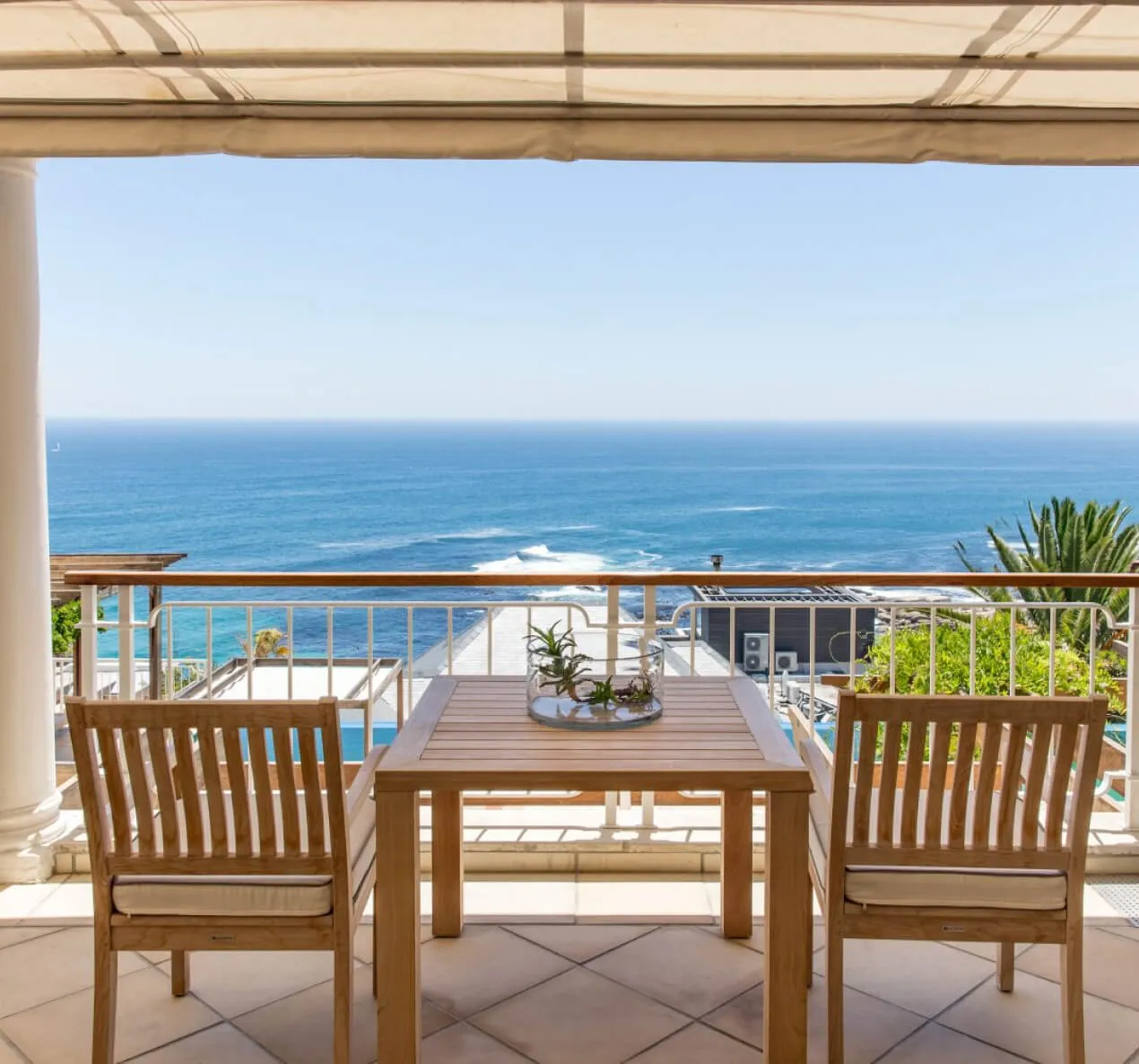 Two chairs and a table on a patio overlooking the ocean