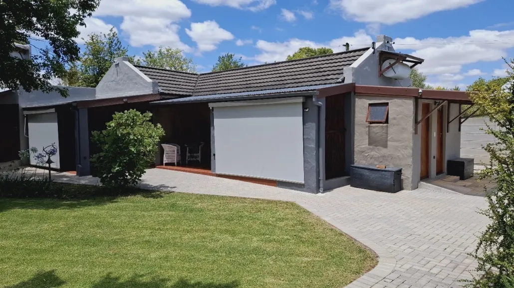 Modern house with a garage patio and wellmaintained lawn under a blue sky