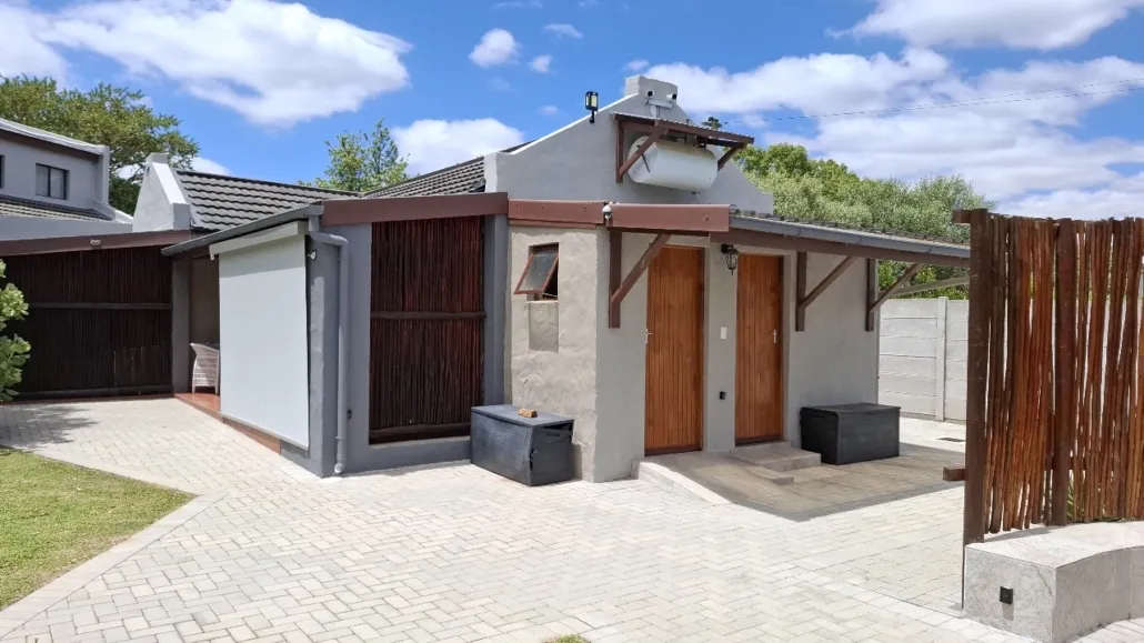 Modern house with wooden doors and windows paved walkway and garden area