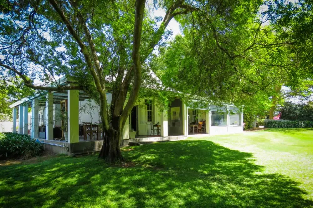A house surrounded by trees with a green lawn in front