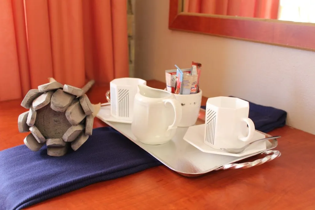 Coffee set on a tray with cups sugar and a decorative object on a table