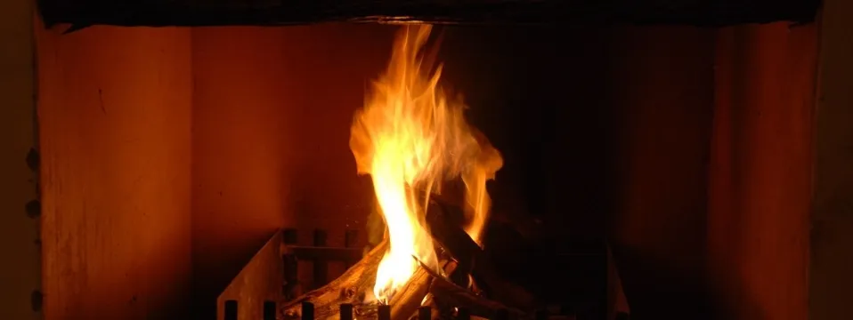 Fire burning in a fireplace with logs and a grate