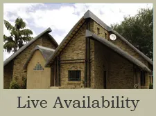 Stone and thatchroofed building with Live Availability text below