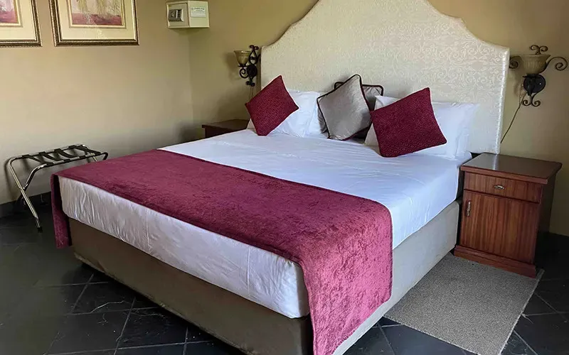 A neatly made bed with red and white bedding in a bedroom