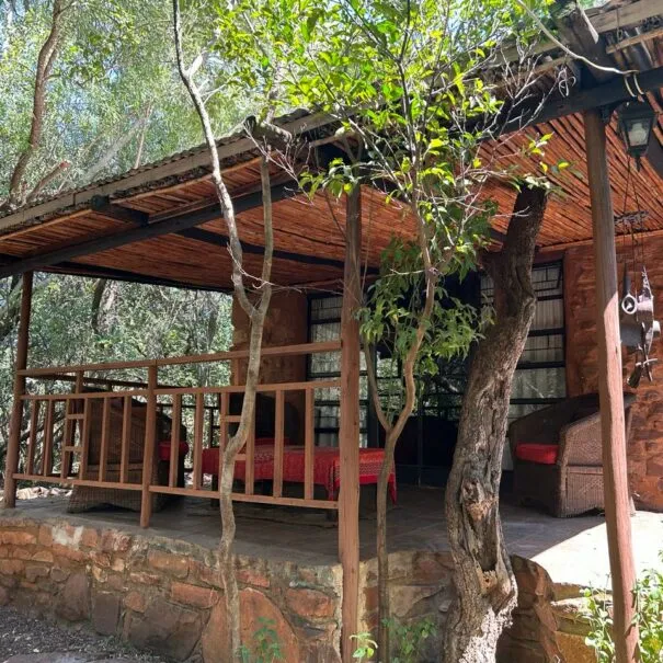 Wooden porch with red bench and trees stone wall in a natural setting