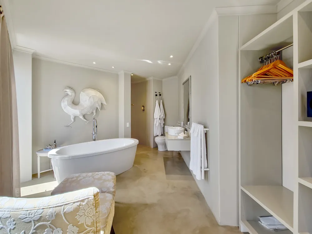 Modern bathroom with large tub robe hooks and seating area