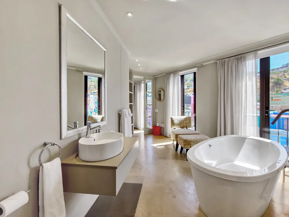 Modern bathroom with freestanding tub sink and large windows overlooking a view