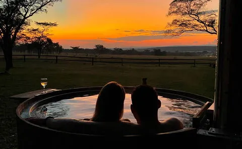 Couple in a hot tub at sunset enjoying a scenic view