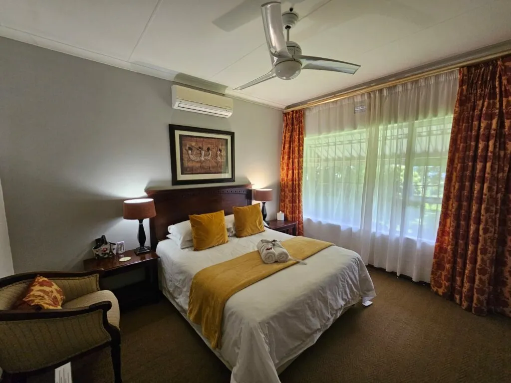 Cozy bedroom with a large bed orange curtains and two windows