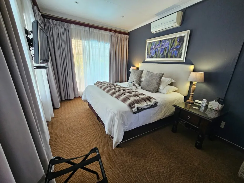 Modern bedroom with large bed TV and artwork above the headboard