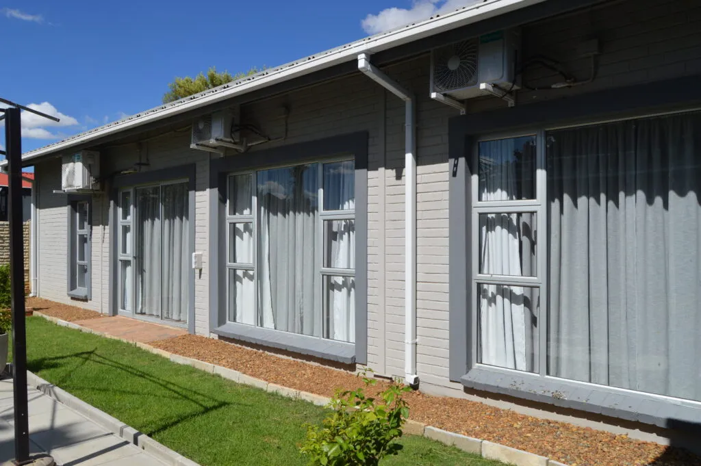 Modern building with large windows grey curtains and air conditioning units outside
