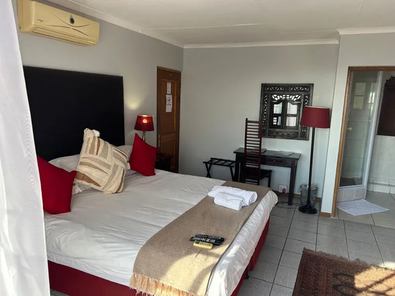 Neat bedroom with a large bed mirror and bedside lamps