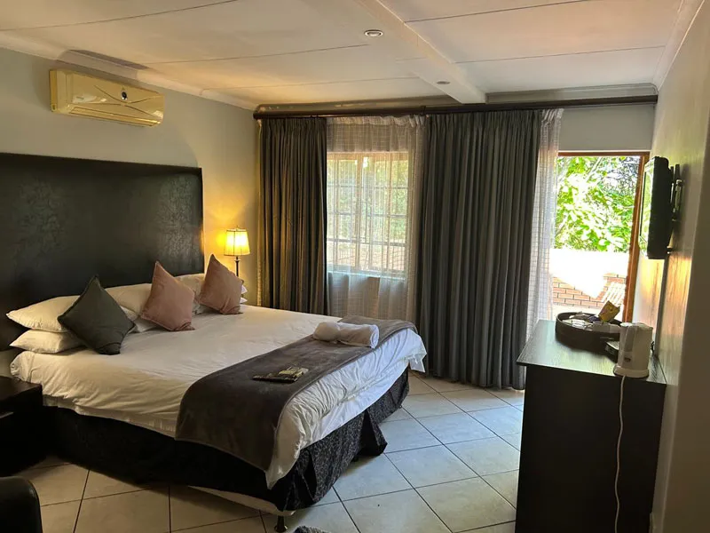 Bedroom with large bed pillows curtains and a window with a view