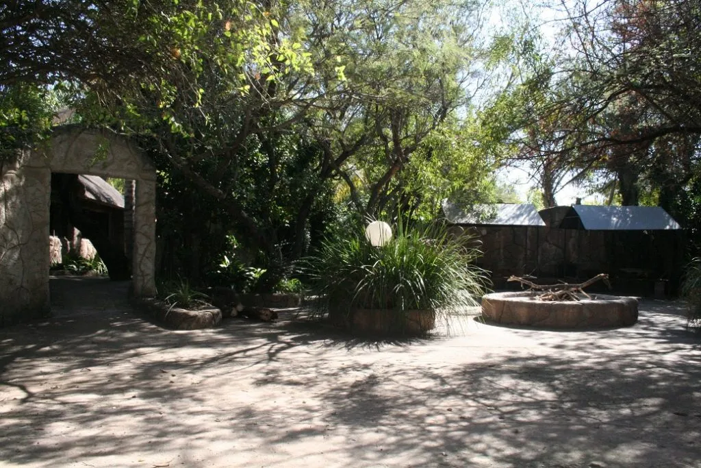 Shaded courtyard with stone archway trees and circular stone bench