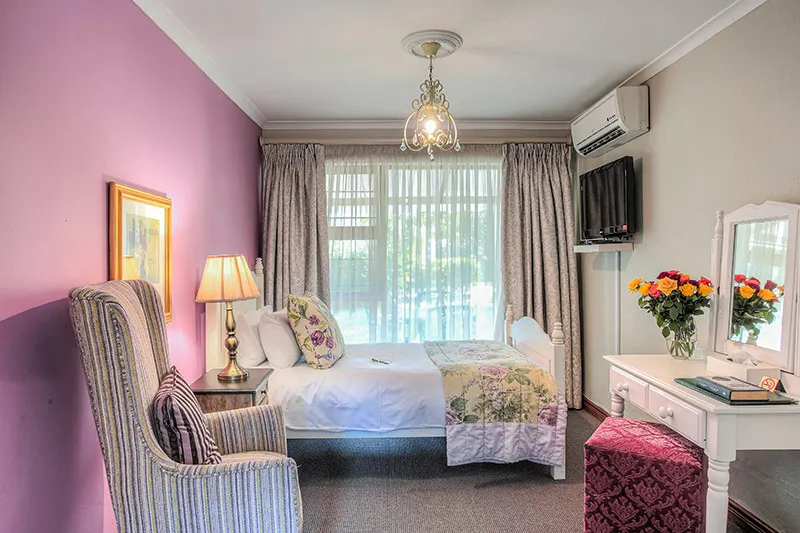 Cozy bedroom with a single bed armchair and vanity table with flowers