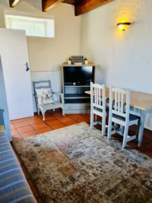 Cozy room with table chairs TV and patterned rug on tiled floor