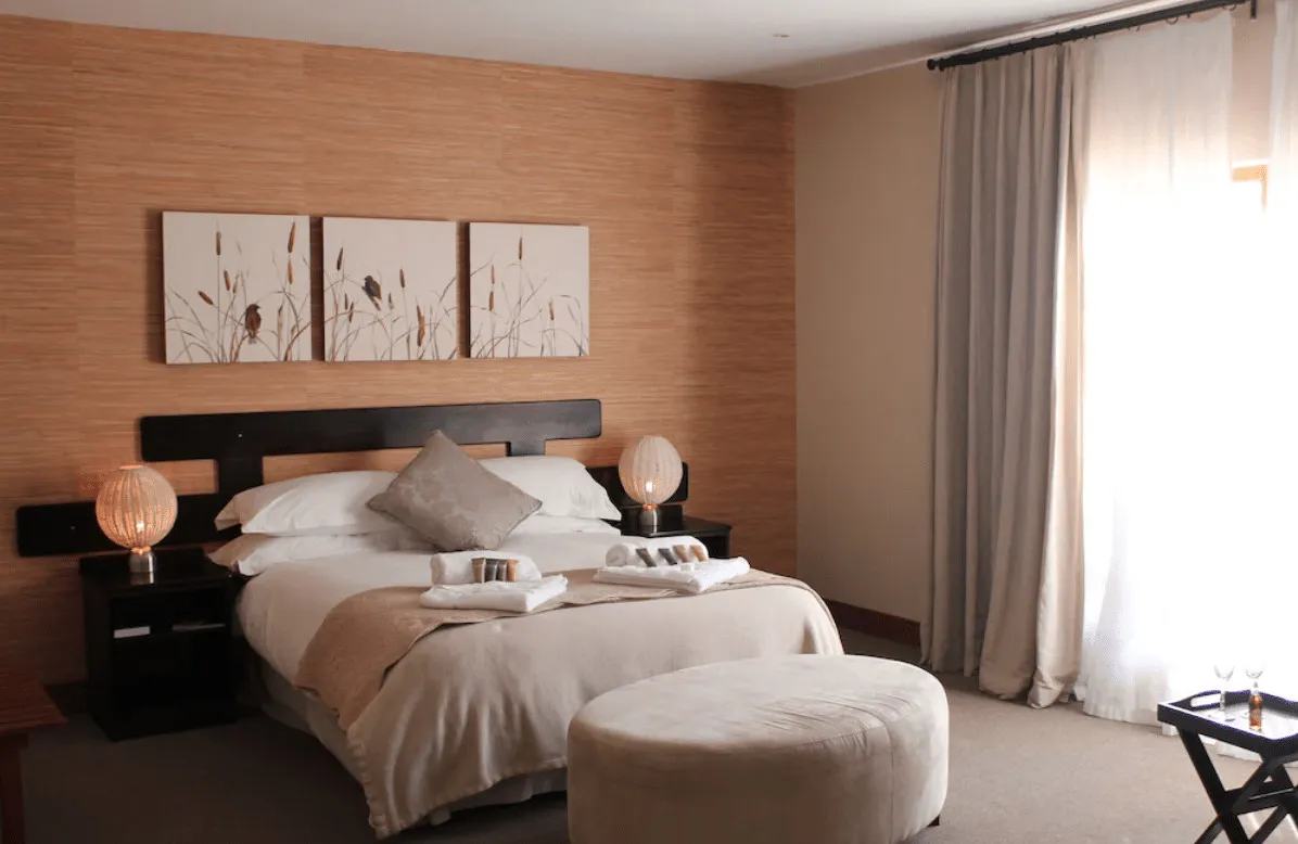 Cozy bedroom with a large bed bedside lamps and a window with curtains