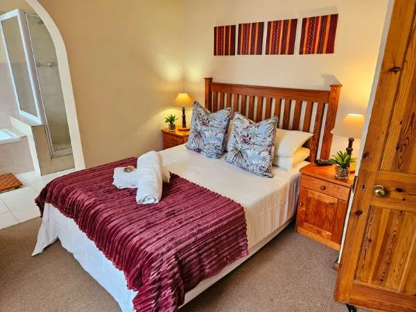 Cozy bedroom with a large bed wooden headboard and bedside tables with lamps