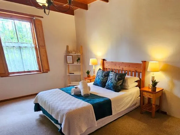 Cozy bedroom with a neatly made bed wooden headboard and bedside lamps