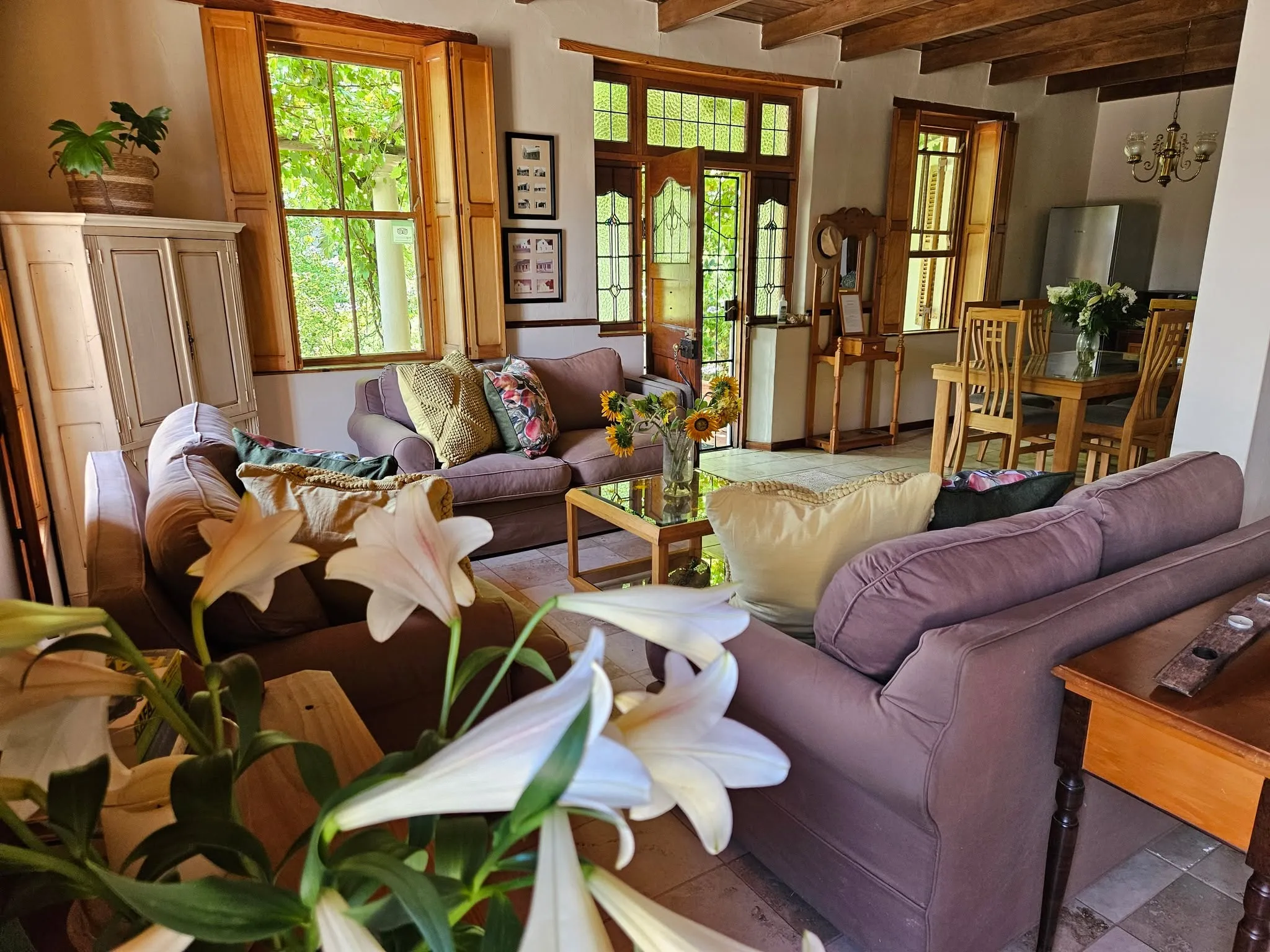 Cozy living room with sofas flowers and large windows letting in natural light