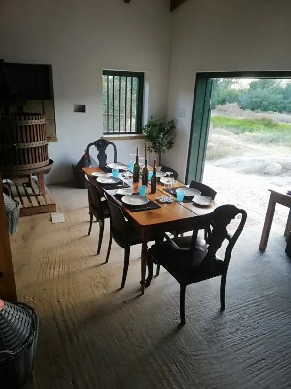 Wooden table set for a meal in a rustic room with open door