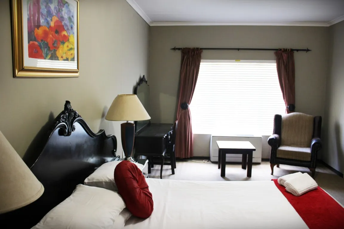 Bedroom with a large bed armchair and window with curtains